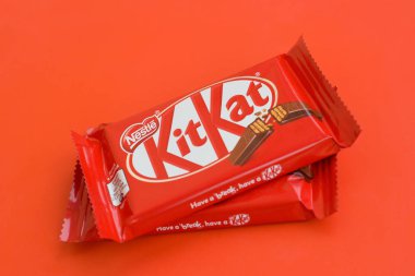 Kırmızı ambalajlı Kit Kat çikolatası kırmızı arka planda yatıyor. Kit Kat, Birleşik Krallık 'ta Rowntree' s of York tarafından yaratıldı ve şimdi küresel olarak Nestle tarafından üretiliyor.