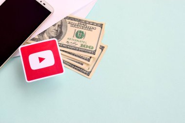 Youtube kağıt logosu dolar ve akıllı telefon dolu zarflarla dolu.