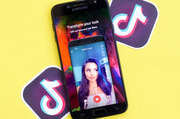 Aplikasi Tiktok pada layar telepon pintar samsung pada latar belakang kuning. TikTok adalah layanan jejaring sosial berbagi video populer yang dimiliki oleh ByteDance — Stok Foto