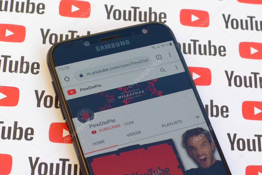 NY, USA - DECEMBER 4, 2019: Pewdiepie official youtube channel on smartphone screen on paper youtube background.