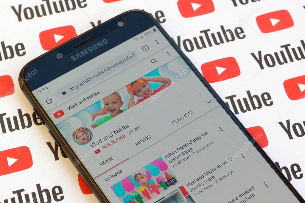 NY, USA - DECEMBER 4, 2019: Vlad and Nikita official youtube channel on smartphone screen on paper youtube background.