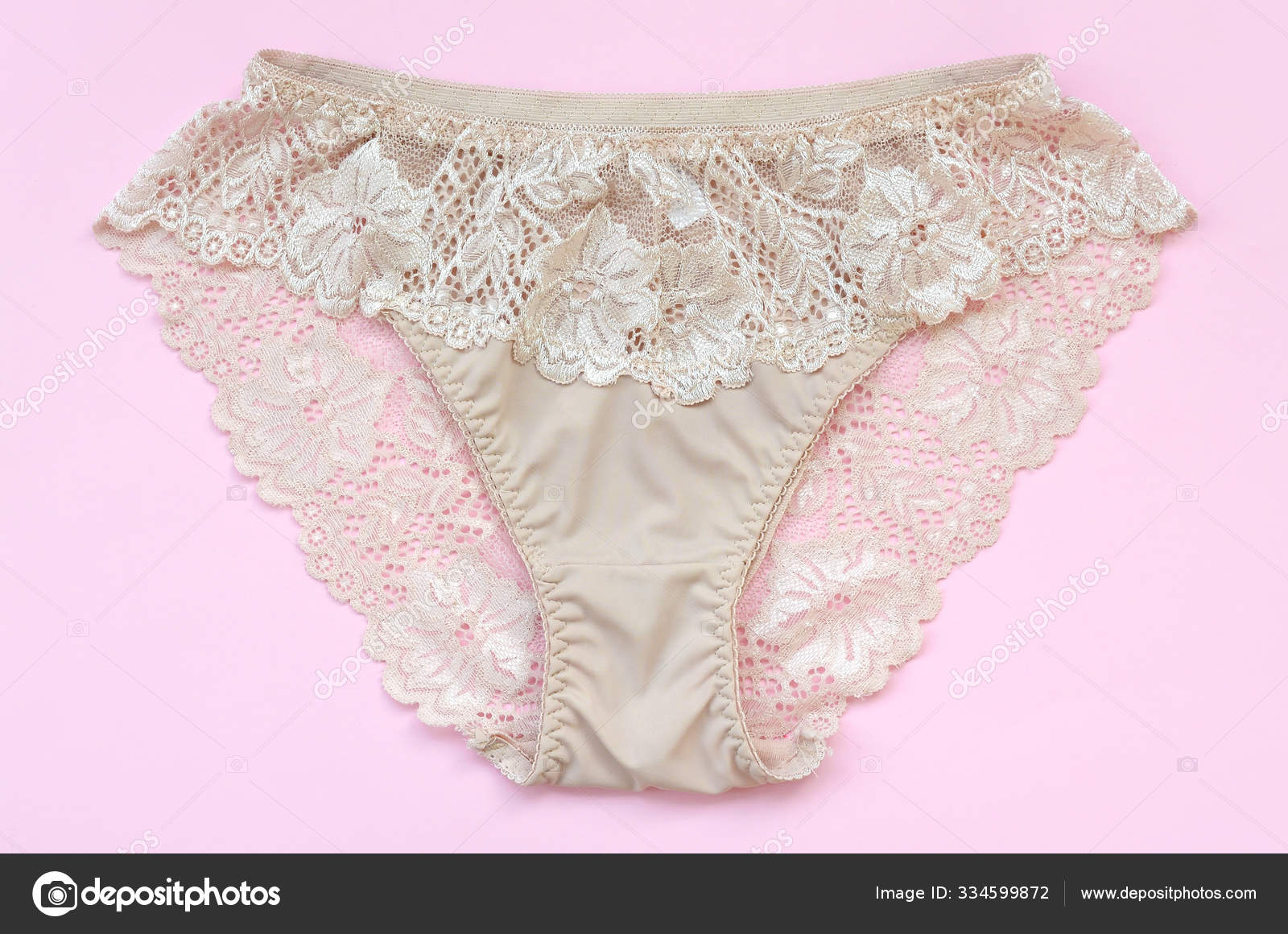 Beige women underwear with lace on pink background with copy space