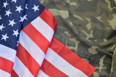 Amerika Birleşik Devletleri bayrağı ve katlanmış askeri üniforma ceketi. Amerikan vatanseverlik bayramları için askeri semboller kavramsal arka plan pankartı