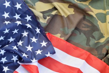 Amerika Birleşik Devletleri bayrağı ve katlanmış askeri üniforma ceketi. Amerikan vatanseverlik bayramları için askeri semboller kavramsal arka plan pankartı
