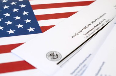 I-526 Immigrant Petition by Alien Entrepreneur blank form lies on United States flag with envelope from Department of Homeland Security clipart