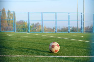 Dışarıda futbol sahasında oynanan klasik futbol topu. Aktif spor ve beden eğitimi