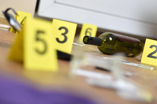 Vidrio roto y botella de vino marcados como evidencia durante la investigación de la escena del crimen. Muchos marcadores amarillos con números — Foto de Stock