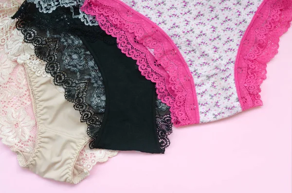 Ropa interior de mujer blanca, negra y rosa con encaje sobre fondo rosa con espacio para copiar. Publicidad para tienda de ropa interior de mujer hermosa y cómoda — Foto de Stock