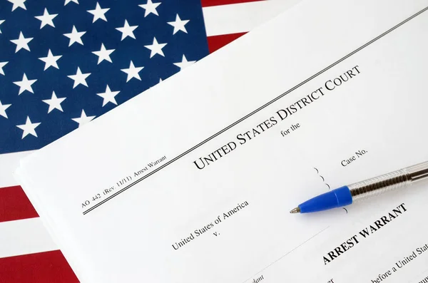 Δικαστικά έγγραφα του Περιφερειακού Δικαστηρίου Σύλληψη εντάλματος σύλληψης και μπλε στυλό στη σημαία των Ηνωμένων Πολιτειών. Άδεια σύλληψης υπόπτου — Φωτογραφία Αρχείου