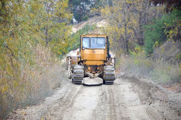 Agregado de cantera con maquinaria pesada. Excavadora cargadora Caterpillar con retroexcavadora que conduce a la cantera del sitio de construcción — Foto de Stock