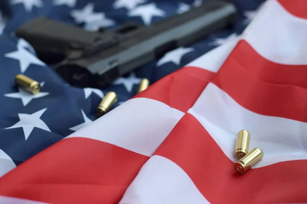 9 мм пули и пистолет лежат на сложенном флаге США — стоковое фото