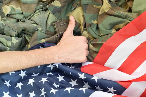 Main montre pouces levés sur le drapeau américain et uniforme militaire — Photo