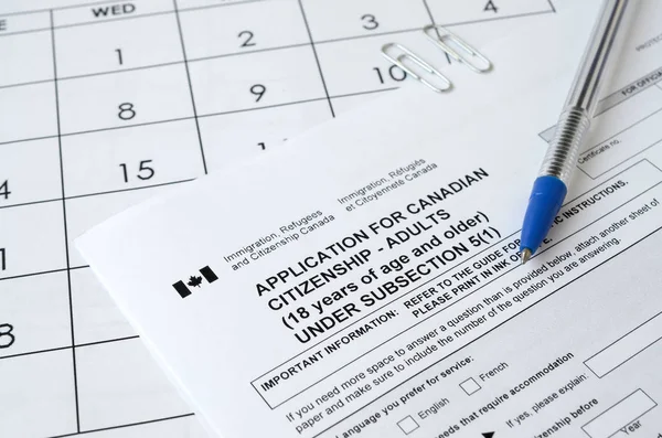 Pedido de cidadania canadense para adultos e caneta azul encontra-se na página de calendário — Fotografia de Stock