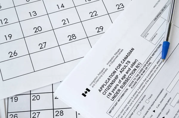 Pedido de cidadania canadense para adultos e caneta azul encontra-se na página de calendário — Fotografia de Stock