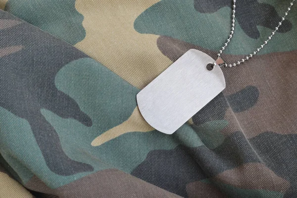 Zilverkleurige militaire kralen met dog tag op camouflage vermoeidheid uniform — Stockfoto