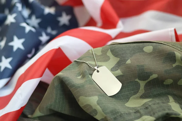 Silvery military beads with dog tag on United States fabric flag and camouflage uniform — Stock Photo, Image