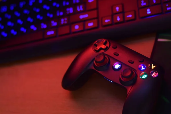 Modern oyun sahası, karanlık oyun odası sahnesinde bilgisayar klavyesiyle kaplıdır. Oyun yayını ve video oyunu yürüyüşü konsepti — Stok fotoğraf