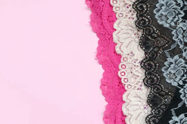 White, black and pink women underwear with lace on pink background with copy space. Advertising for shop of beautiful and comfortable women underwear