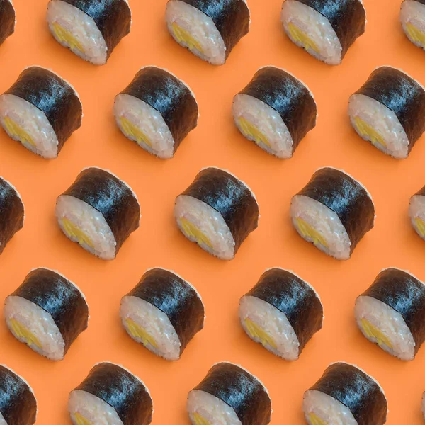明亮橙色背景下经典的黑寿司卷 — 图库照片