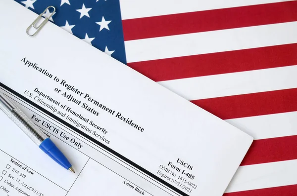 I-485 Het verzoek om een permanente verblijfsvergunning of een blanco formulier voor de aanpassing van de status ligt op de vlag van de Verenigde Staten met blauwe pen van het ministerie van Binnenlandse Veiligheid — Stockfoto