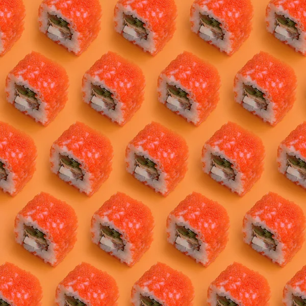California Maki sushi broodjes met kaviaar en masago op oranje achtergrond. Minimalisme bovenaanzicht plat lay patroon met Japans eten — Stockfoto