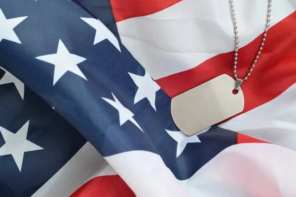 Silvery military beads with dog tag on United States fabric flag — Stock Photo, Image