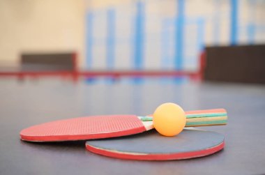 Raketler ve top dışarıdaki spor sahasında masa tenisi masasında. Aktif spor ve beden eğitimi konsepti