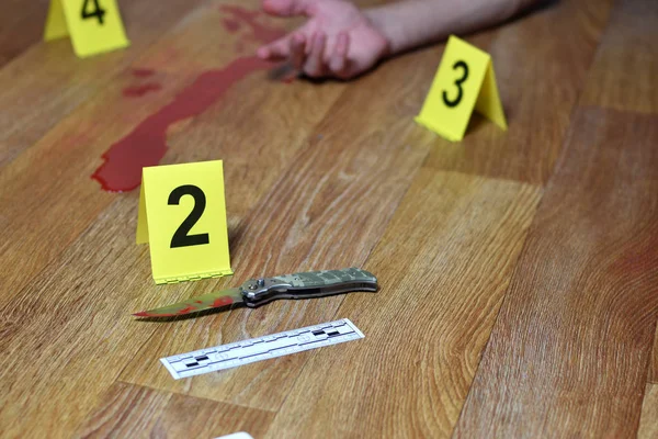 犯罪現場調査-血のナイフと被害者手とともに黄色犯罪者マーカー上のキッチンフロア — ストック写真
