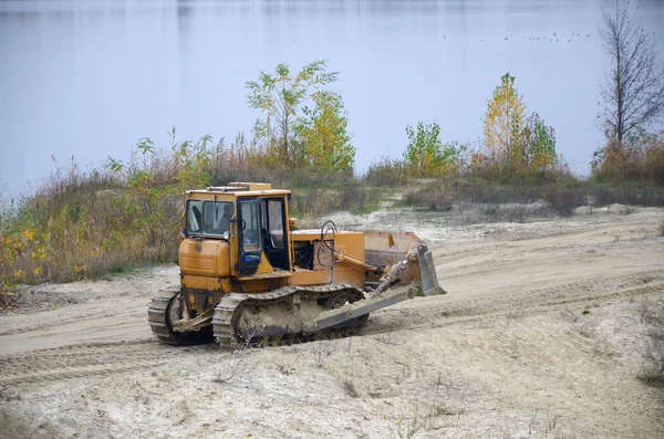 Agregado de cantera con maquinaria pesada. Excavadora cargadora Caterpillar con retroexcavadora que conduce a la cantera del sitio de construcción — Foto de Stock