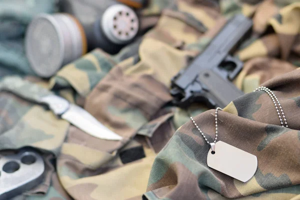 Stalker soldiers soviet gas mask lies with handgun and knife on green khaki camouflage jackets — Stock Photo, Image