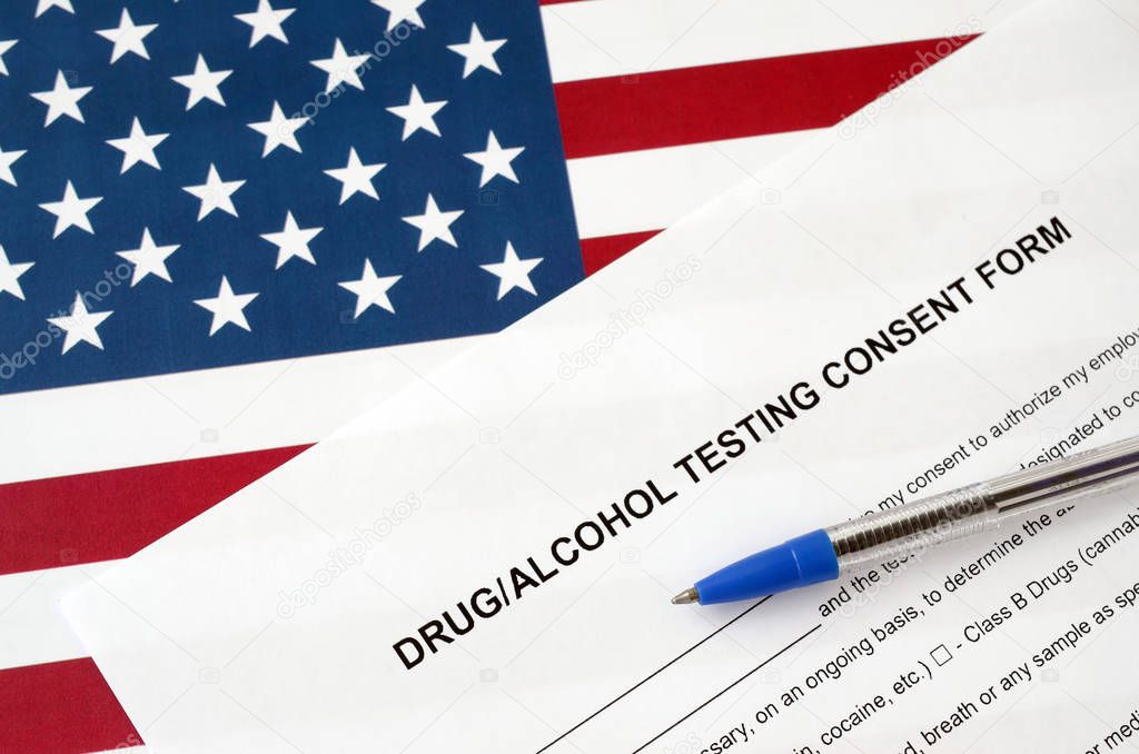 Drug and alcohol testing consent form with blue pen on United States flag