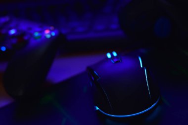 Modern oyun sahası ve oyun faresi karanlık oyun odası sahnesinde klavye ve kulaklıklarla yatar. Video oyunu Speedrun konsepti veya Esports yarışması meydan okuması