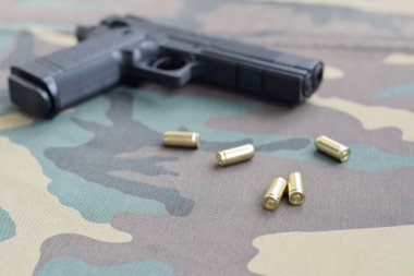 9mm 'lik mermiler ve tabancalar kamuflaj yeşil kumaşın üzerinde. Atış menzili ya da savunma kiti.