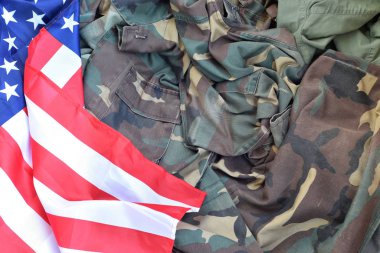 Amerika Birleşik Devletleri bayrağı ve katlanmış askeri üniforma ceketi. Amerikan vatanseverlik bayramları için askeri semboller kavramsal arka plan pankartı
