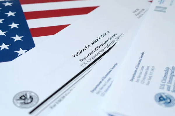 I-130 Petition for alien relative blank form lies on the United States flag with obálka from Department of Homeland Security — Stock fotografie