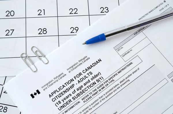 Pedido de cidadania canadense para adultos e caneta azul encontra-se na página de calendário — Fotografia de Stock