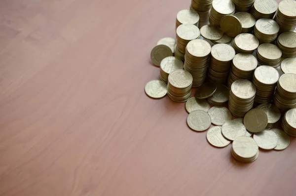 Grande quantidade de moedas velhas ucranianas brilhantes de 1 hryvnia fecham em cima da mesa de madeira. O conceito de negócio e vida rica na Ucrânia — Fotografia de Stock