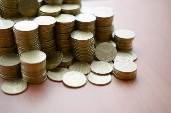 Велика кількість блискучих україніанських старих монет 1 гривні закриті на дерев'яному столі. Концепція ділового та багатого життя в Україні — стокове фото