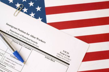 Yabancı işçiler için I-140 göçmen dilekçesi ABD bayraklarında İç Güvenlik Bakanlığı 'ndan mavi kalemle duruyor.