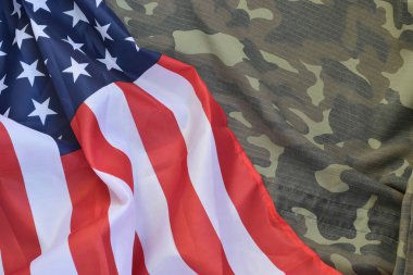 Amerika Birleşik Devletleri bayrağı ve katlanmış askeri üniforma ceketi. Amerikan vatanseverlik bayramları için askeri semboller kavramsal arka plan pankartı