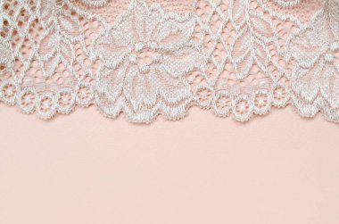 Kağıt arkaplanda dantelli ve fotokopi alanı olan bej kadın iç çamaşırı. Güzellik moda blogcusu konsepti. Sevgililer Günü cazibesi için romantik iç çamaşırı.