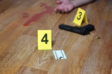 Yerde silah ve cesetle kanlı bir suç mahalli. Birçok olay yeri inceleme ekipleri içeride.