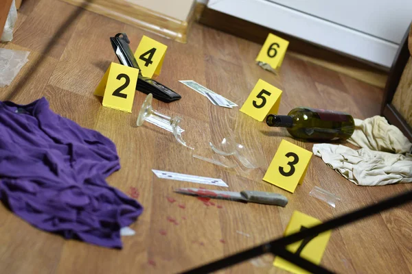 Helyszíni nyomozás. Bizonyítékok számozása a lakásban történt gyilkosság után. Kés ruhákkal, pénztárcával és üveg borral bizonyítékként — Stock Fotó