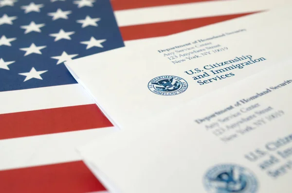 Sobres con carta de USCIS sobre bandera de Estados Unidos del Departamento de Seguridad Nacional —  Fotos de Stock