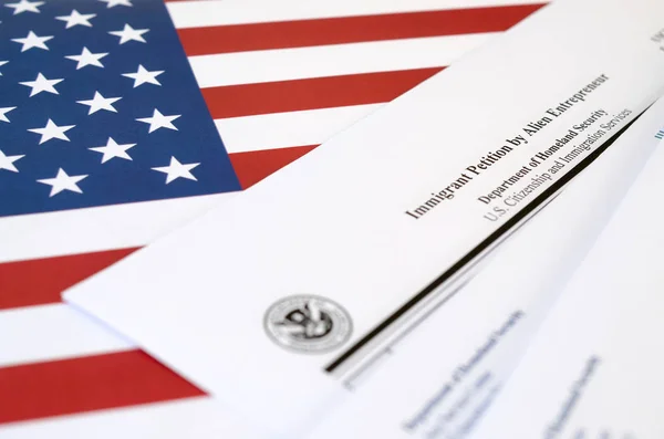 I-526 Immigrant Petition by Alien Entrepreneur blank form lies on United States flag with envelope from Department of Homeland Security — 스톡 사진