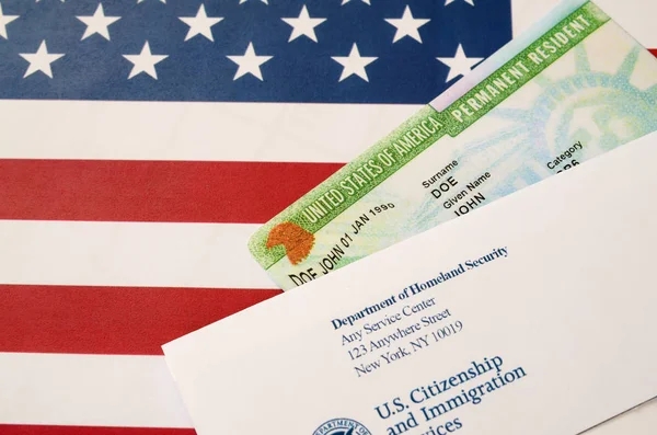 Stany Zjednoczone Stały rezydent zielonej karty z dv-loteria leży na fladze Stanów Zjednoczonych z kopertą z Departamentu Bezpieczeństwa Wewnętrznego — Zdjęcie stockowe