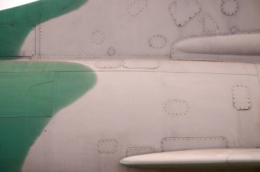 Eski savaş uçağı vücudunun kirli ve detaylı dokusu kamuflajla birçok perçinle boyanmış.