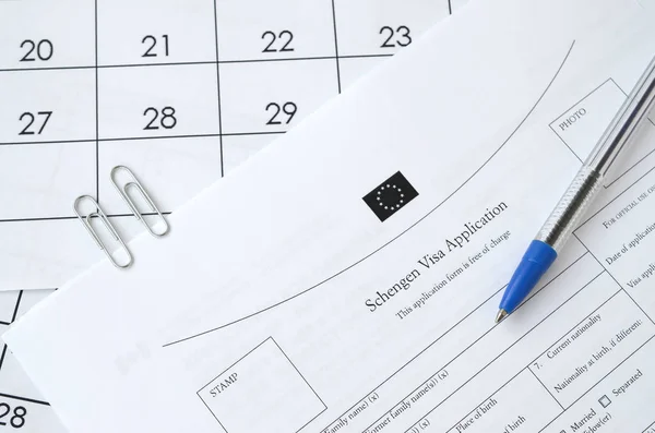 Schengen Visumsantrag und blauer Stift auf Papierkalenderseite — Stockfoto