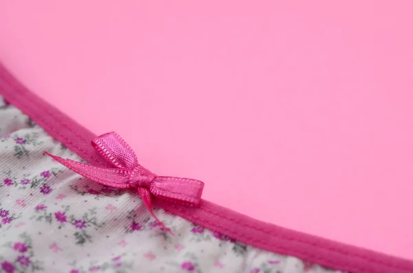 Stuha na bílé dámské spodní prádlo s krajkou na růžovém pozadí s kopírovacím prostorem. Krása módní blogger koncept. Romantické spodní prádlo na Valentýna pokušení — Stock fotografie