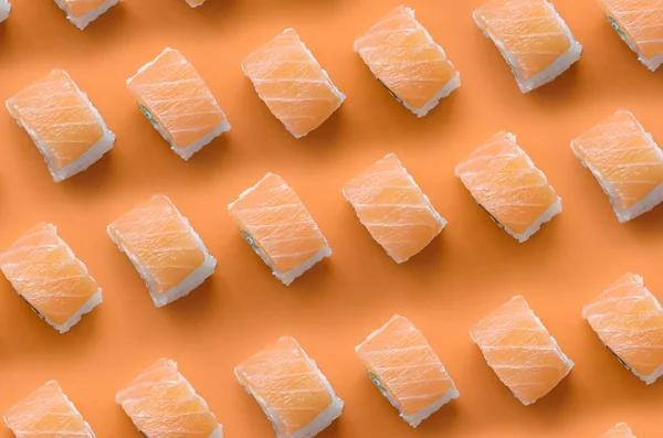 Filadélfia rola com salmão sobre fundo laranja. Minimalismo vista superior plano leigos padrão com comida japonesa — Fotografia de Stock